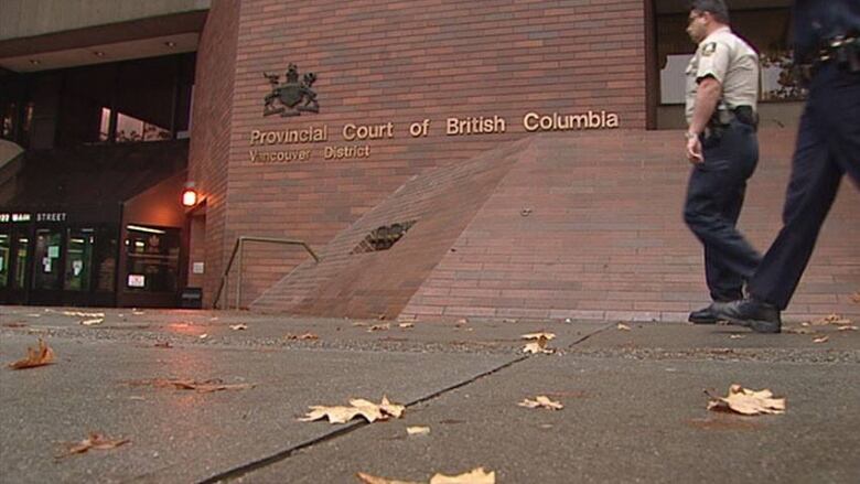 Sheriffs walk past Vancouver's provincial courthouse