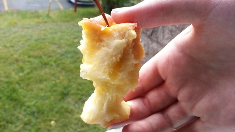 A hand holding a mostly eaten apple that is starting to brown.