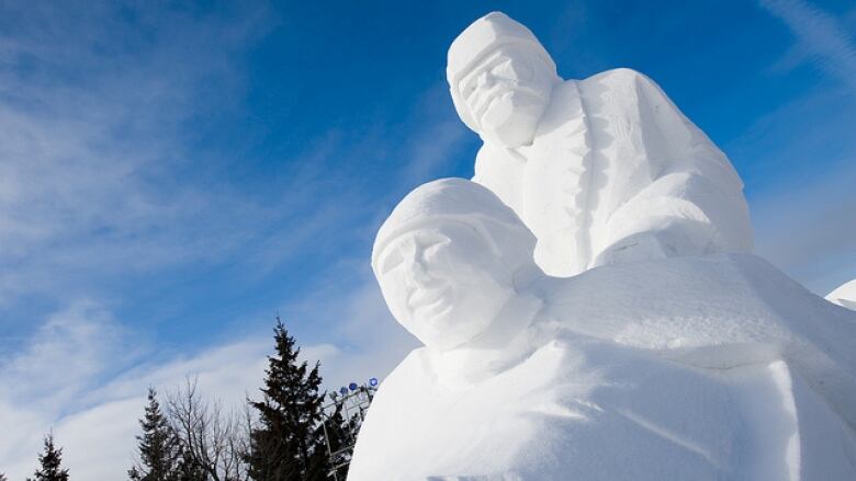 A snow sculpture shows the faces of two men