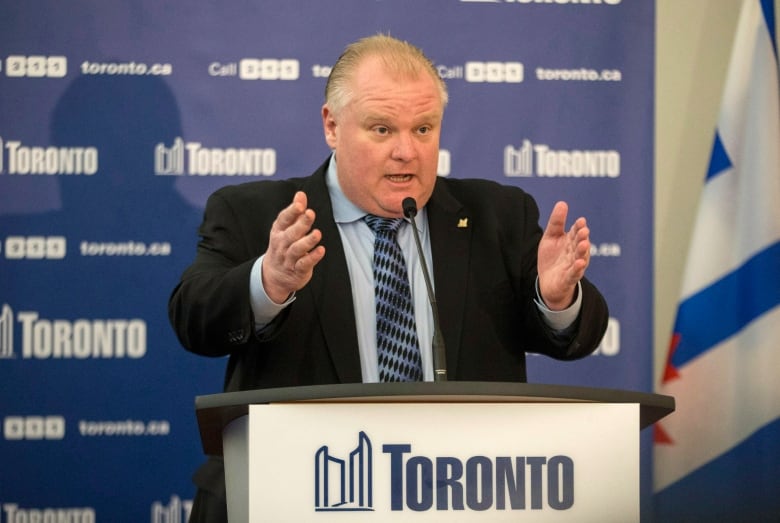 Man in a suit speaking at a podium