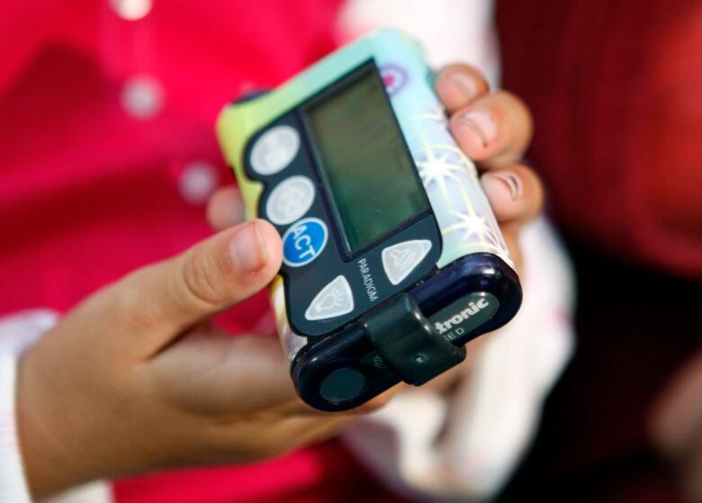 Seven-year-old Ellie Clark holds her insulin pump, which also works with an implant to display blood sugar levels, Wednesday, Sept. 12, 2007, in Grandville, Mich. Diabetes care is undergoing a transformation. Thousands of patients are switching from a few finger-pricks a day to track their disease to new sensors that keep guard around the clock. The last six months brought big boosts to the technology, as federal health officials approved the first model for children _ one that works for three days in a row _ and the longest-working version yet, a seven-day model for adults. The ultimate goal is to create an 