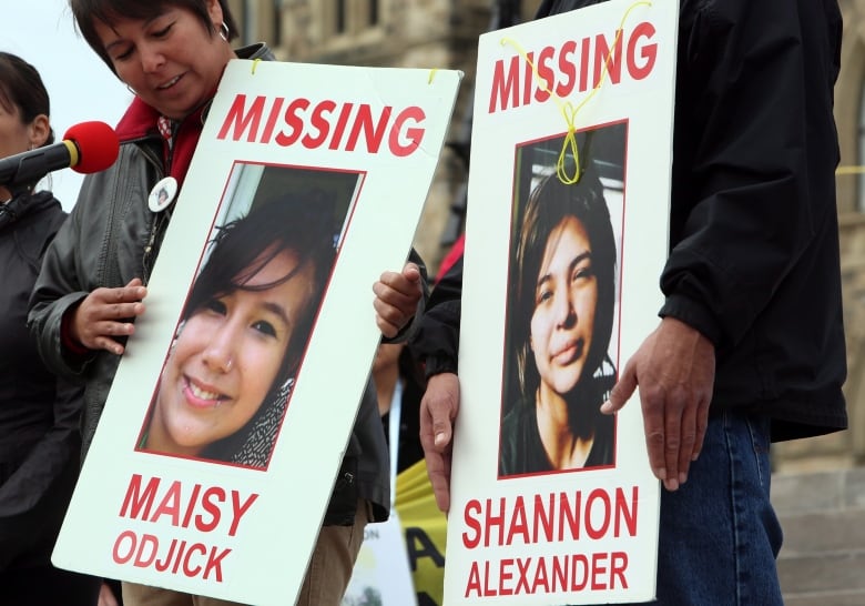 Woman holds a sign.