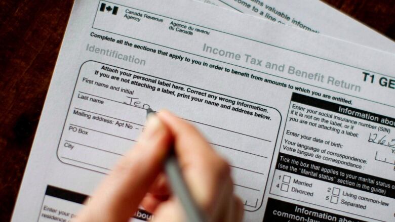 Hand filling out a personal tax form