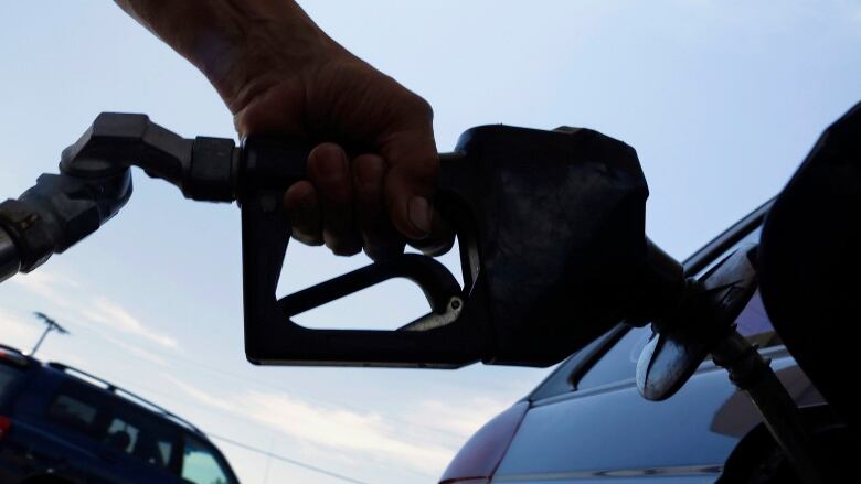 A person putting gas in a car.