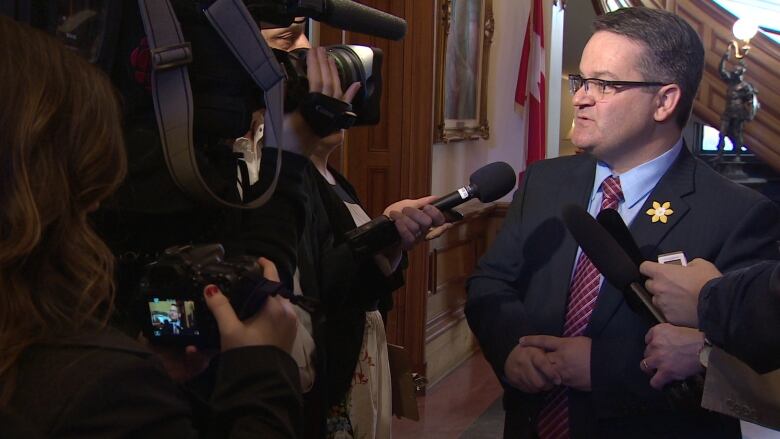 A man speaking with reporters in the legislature rotunda.