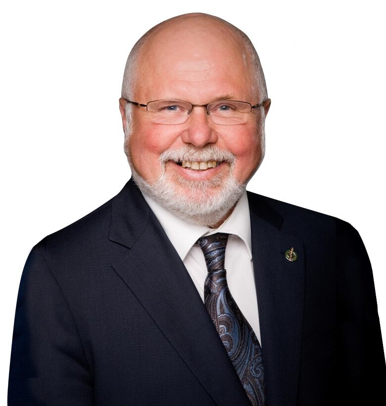 A man in a black suit, purple and blue tie and a white shirt underneath.