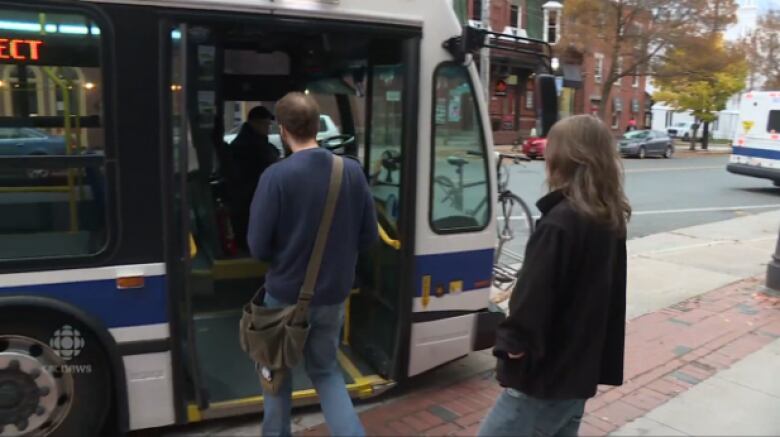 People get on a transit bus.