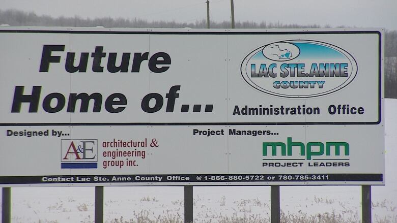 A sign on a snowy day lists A&E Architectural & Engineering Group as the project designer and MHPM Project Leaders as the project managers.