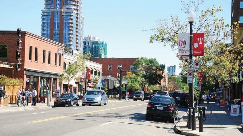 A street is pictured with cars parked on the side.