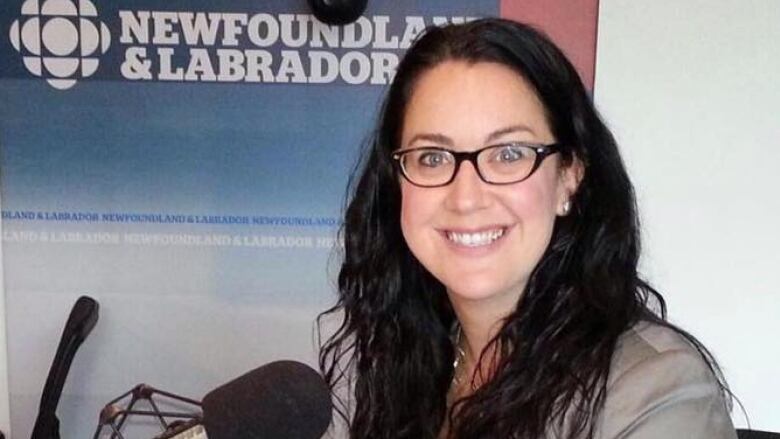 A smiling woman sits in a radio studio.