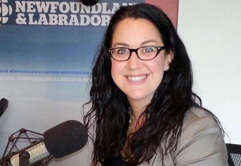 A smiling woman sits in a radio studio.