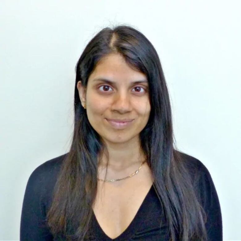 A woman wearing a black shirt smiles at the camera.