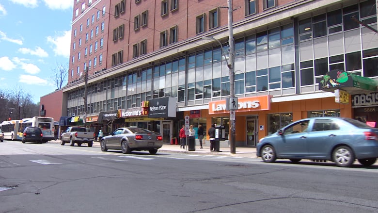 Cars drive past businesses and restaurants 