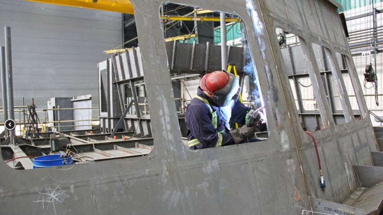 A welder works on the first Offshore Fisheries Science Vessel at the Seaspan shipyard in North Vancouver