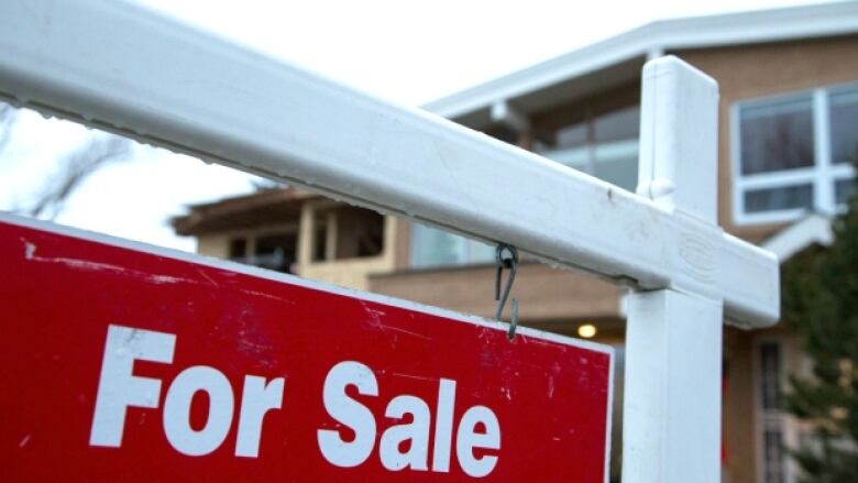 A large for sale sign in front of a home.