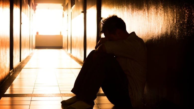 Boy sits on floor of detention centre.