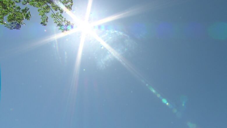 The sun is seen in a blue sky.