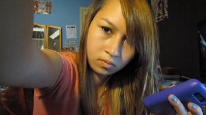 Amanda Todd holding a cell phone.