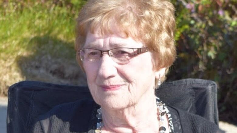 a portrait style photo of an older woman wearing glasses.