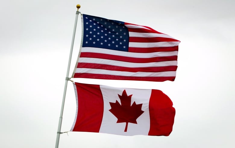 An American flag on top of a Canadian flag.