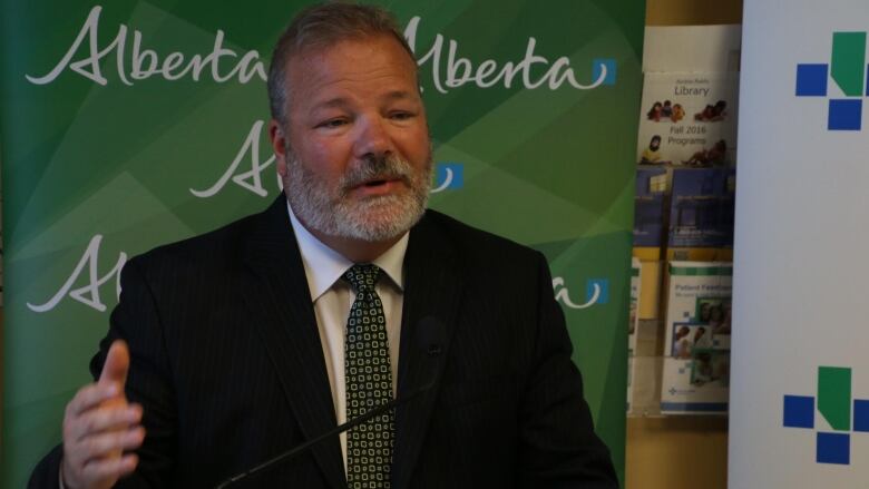 A bearded man in a dark suit speaks at a public event in this file photo.