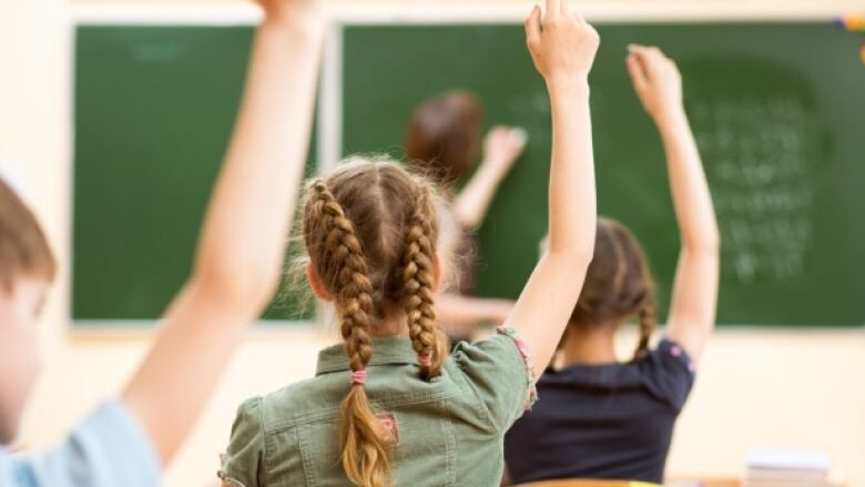 A girl raising her hand in class.