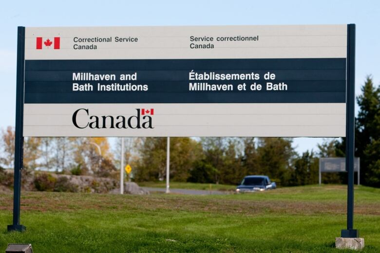 A sign with the Canadian flag and Government of Canada logo identifies the site of the Millhaven and Bath Institutions.