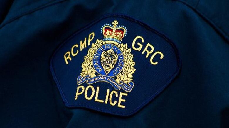 Navy uniform with badge that reads RCMP GRC POLICE on it, in the centre is a gold and red crest.