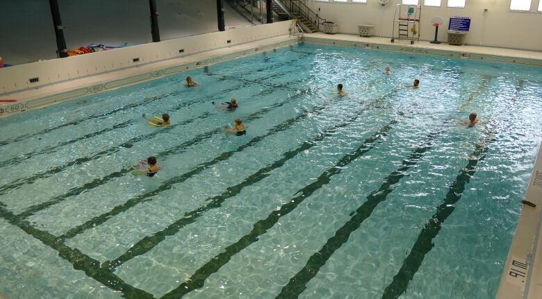 An indoor pool with people swimming.