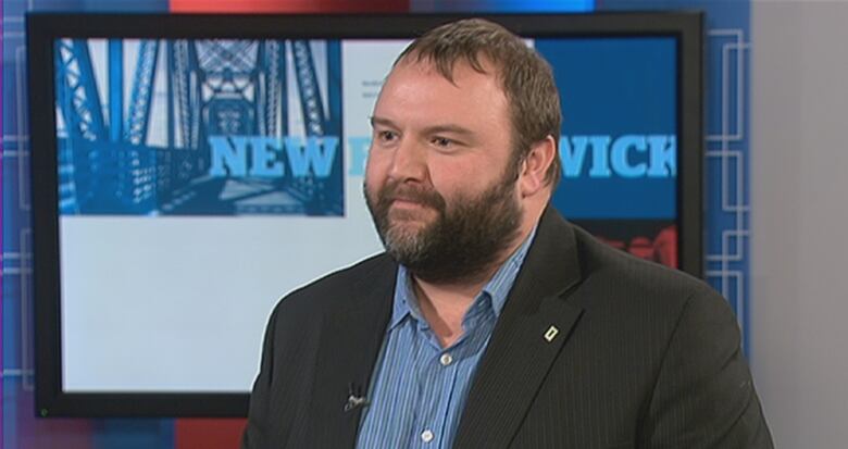 A person in a suit in the CBC TV studio.