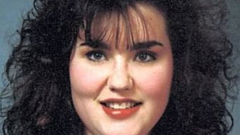 Rene Sweeney smiles and looks straight into the camera, with dark hair surrounding her face. 