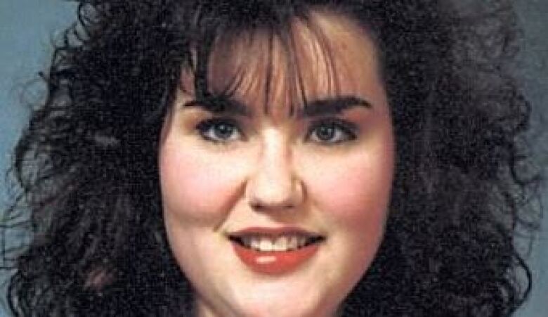 Rene Sweeney smiles and looks straight into the camera, with dark hair surrounding her face. 