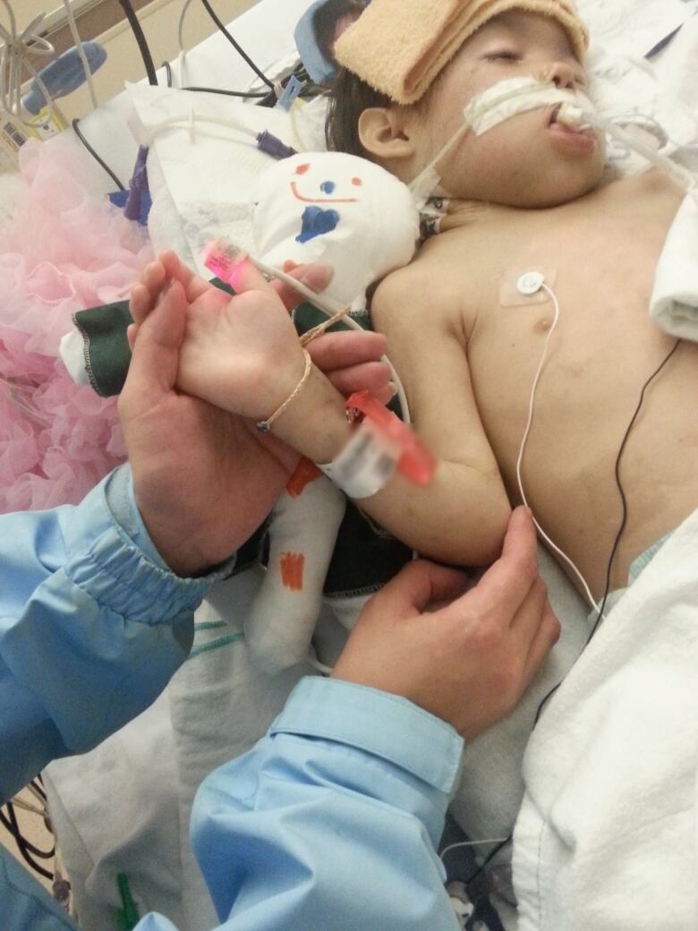 A little girl in a hospital bed.