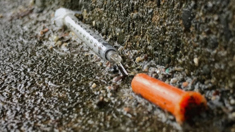 Close-up of a needle on the ground.