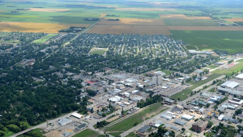 An aerial view shows a small city surrounded by farmland.