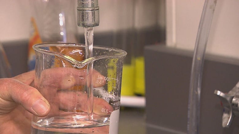 hand holding glass under running tap