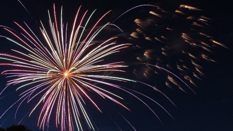 Bright coloured lights in night sky as part of fireworks display