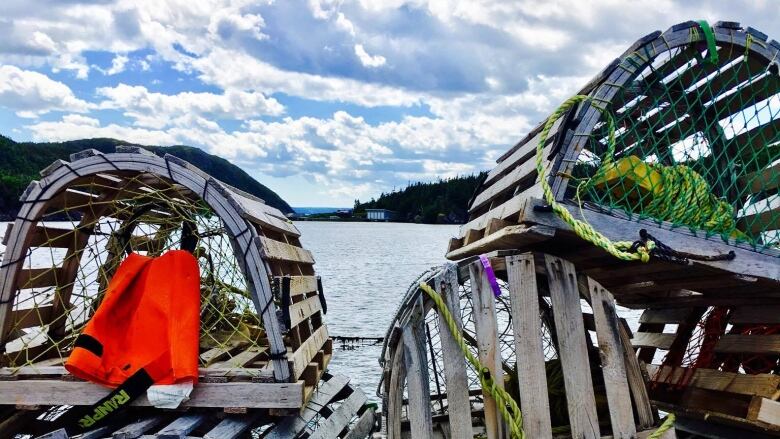 Lobster traps piled up on a dock.