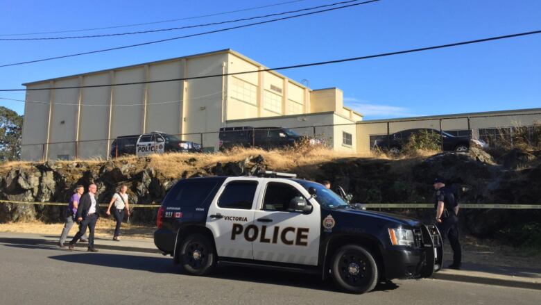 A Victoria Police car in front of crime tape near a school building.