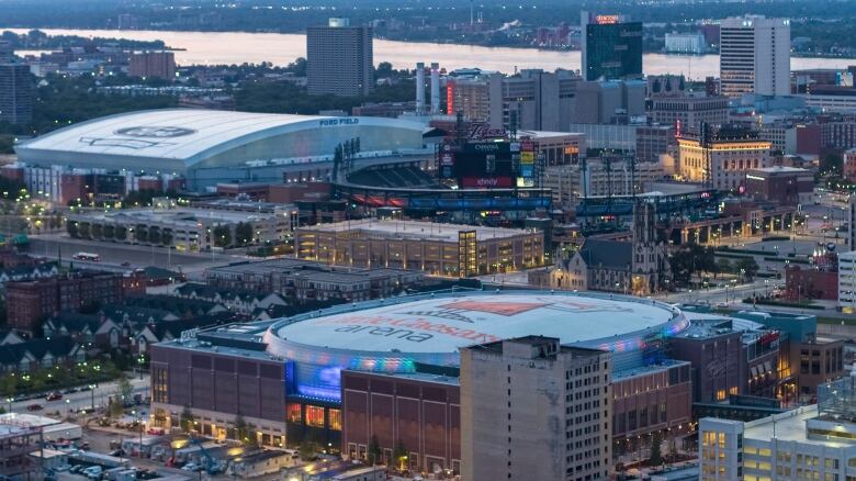 In an undated photo provided by Olympia Development of Michigan, Little Caesars Arena, foreground, is seen in Detroit with Ford Field and Comerica Park in the background. Chris Ilitch looked and sounded like an excited tour guide for nearly two hours, giving The Associated Press an exclusive look inside Little Caesars Arena. The future home of the Detroit Red Wings and Pistons is the gem of a $1.2 billion, 55-block development dubbed The District Detroit.