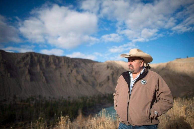 An Indigenous man wearing a wide-brimmed hat is pictured outdoors.