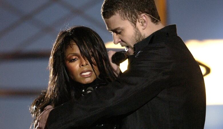 A woman and a man sing on a stage