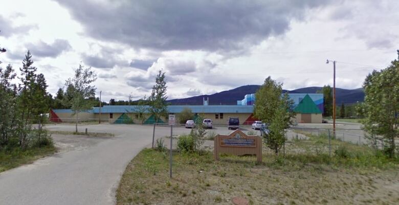 The photo shows the front of an elementary school surrounded by trees.