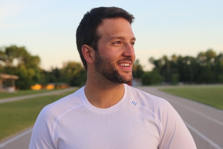 A man smiling while looking away from the camera. 