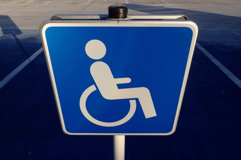 An accessible parking sign in blue