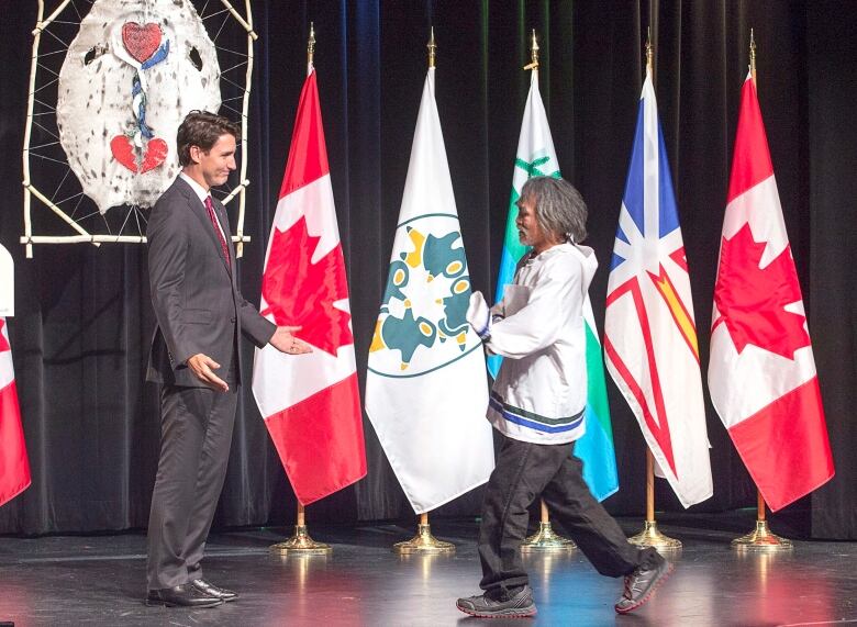 Justin Trudeau welcoming Toby Obed to a stage.