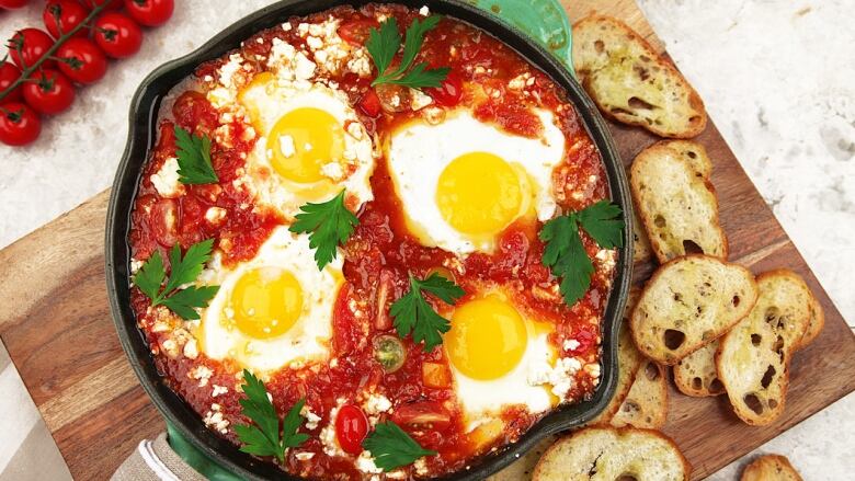 Overhead shot of a cast iron skillet with shakshuka in it. 