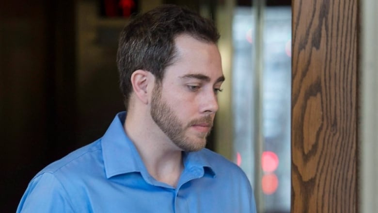 A bearded man in a blue shirt is seen in profile