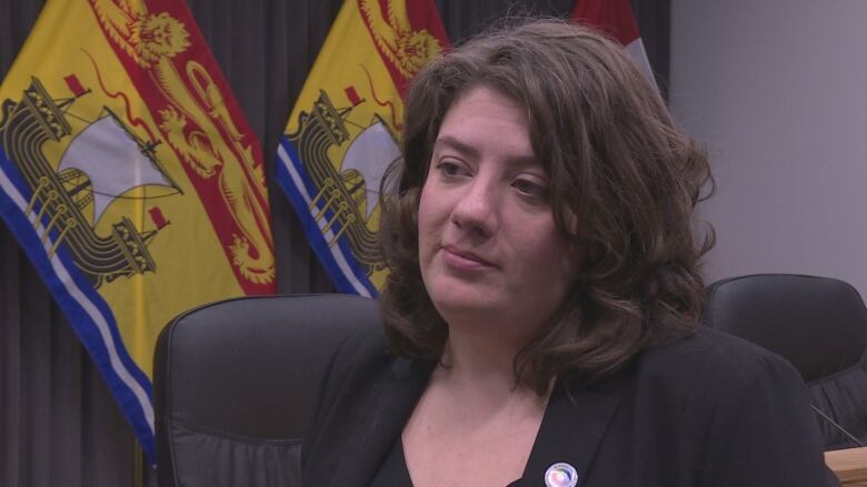 Woman in foreground, New Brunswick flags in background