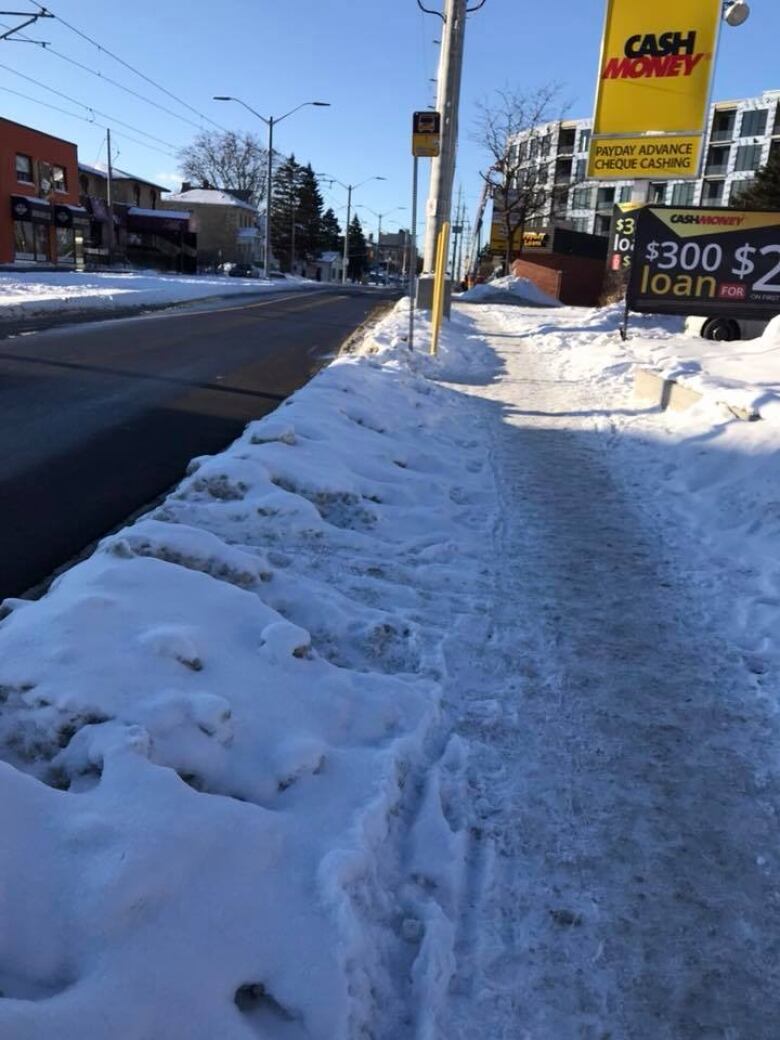 high snow bank next to a sidewalk - only option is to share the road with cars